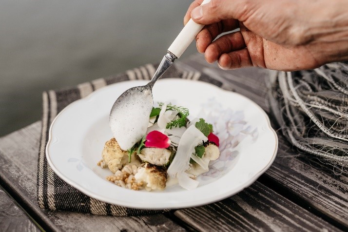 Beatiful cauliflower dish decorated with wild herbs and flower petals.