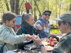 Ihmisiä piknik-pöydän ympärillä. Taiga Times.